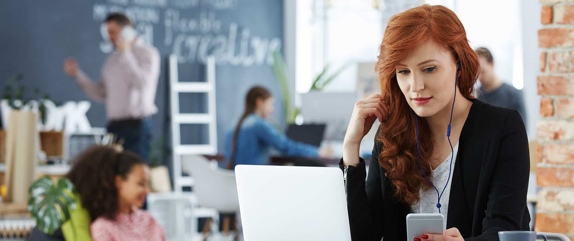 Stylish young businesswoman working on her laptop in modern office